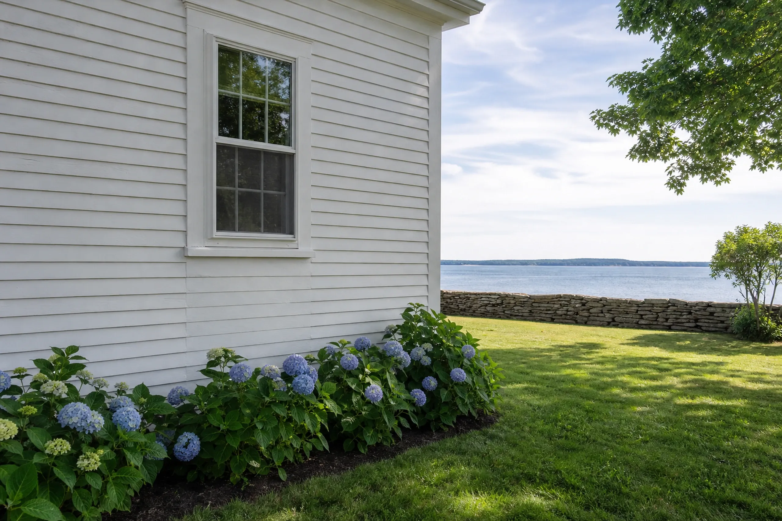 Cumberland Foreside, ME shore home: repaired section of painted white clapboard blended into the old wall below a window, Casco Bay water beyond, summer.
